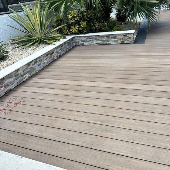 Brownstone vinyl deck meeting a stone-faced planter wall