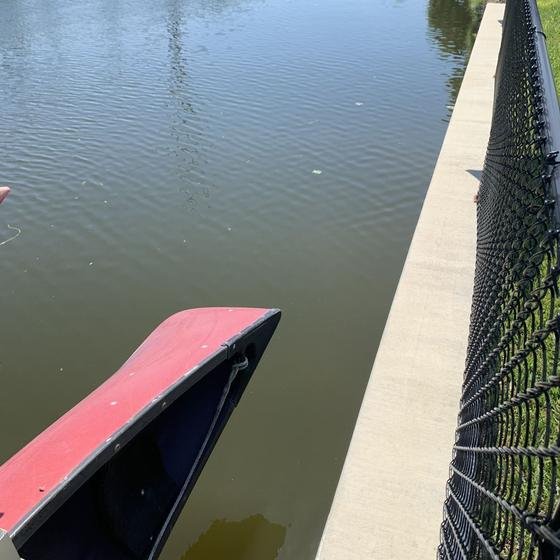 Canoe held on its lift alongside the seawall