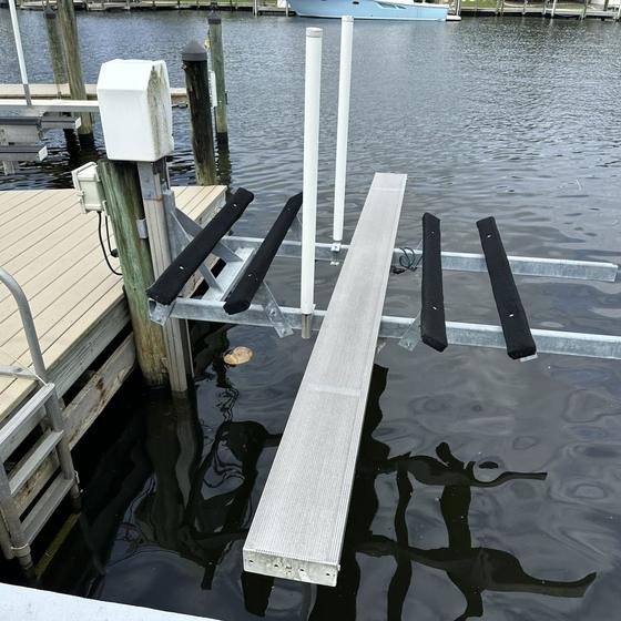 Kayak lift with padded bunks and an aluminum walkboard beside a Slate Gray vinyl dock, top view