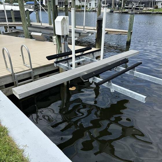 Kayak lift with padded bunks and an aluminum walkboard next to a Slate Gray vinyl dock and ladder
