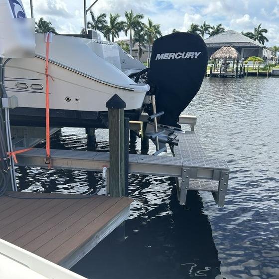 Aluminum walkboard beside a boat lift for servicing outboard motors