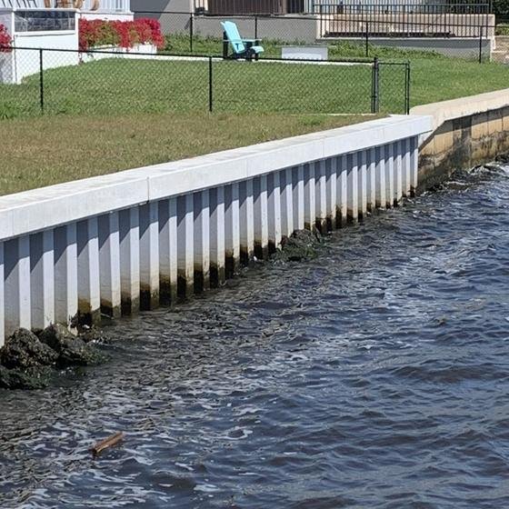 New white vinyl seawall with concrete cap