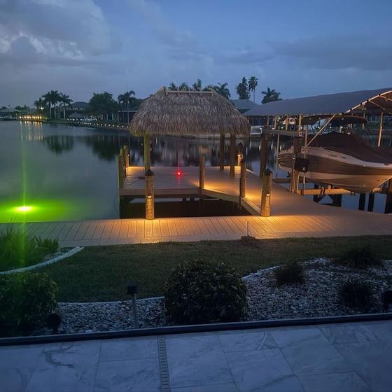 Tiki hut, covered lift and dock lights at dusk with underwater light