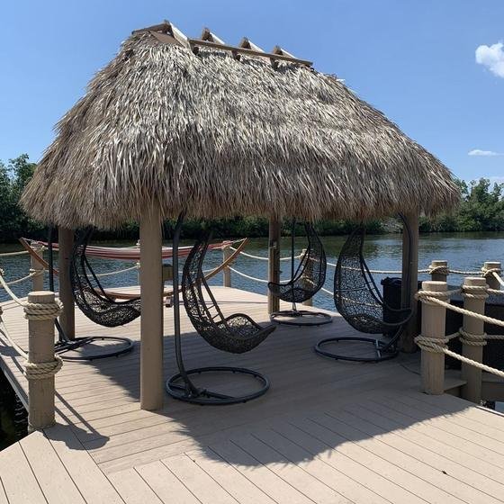Rectangular tiki hut with hanging egg chairs