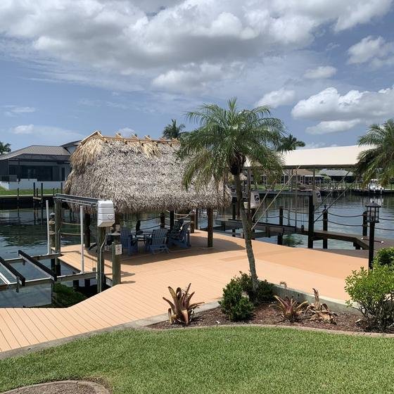 Long rectangular tiki hut on a vinyl dock next to a boat lift